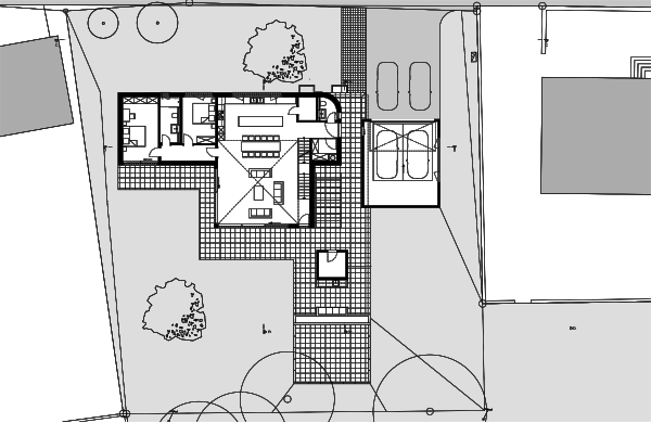 Les chambres à gauche, le séjour sur deux niveaux au centre, le garage séparé à droite, les terrasses dallées et le jardin